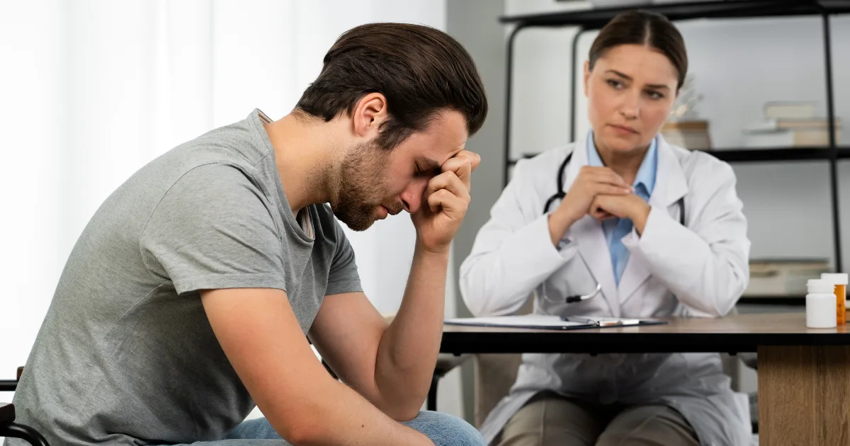 Man experiencing emotional distress during a consultation with a healthcare professional.
