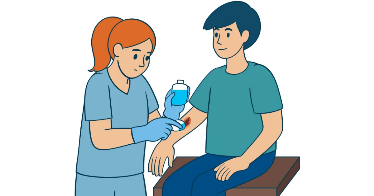 Nurse cleaning a minor wound on a patient’s arm during first-aid treatment.